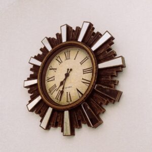 A decorative sunburst clock with roman numerals